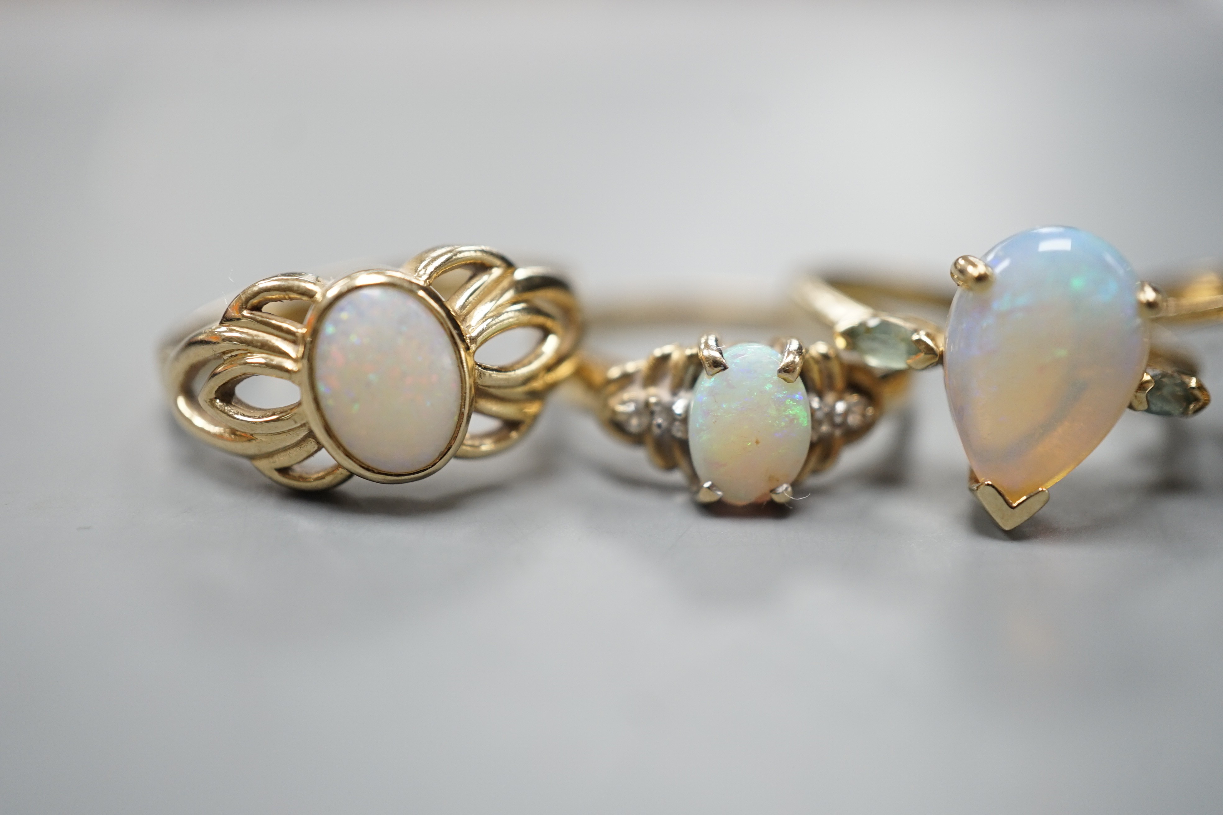 Five assorted modern 9ct gold and gem set dress rings, including white opal and garnet oval cluster, white opal and diamond chip and single stone white opal